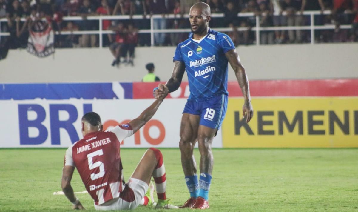 Striker Persib, David da Silva membantu bek Persib Jaime Xavier untuk berdiri pada laga pekan ketujuh Liga 1 2023/2024 di stadion Manahan, Selasa (08/08/23).