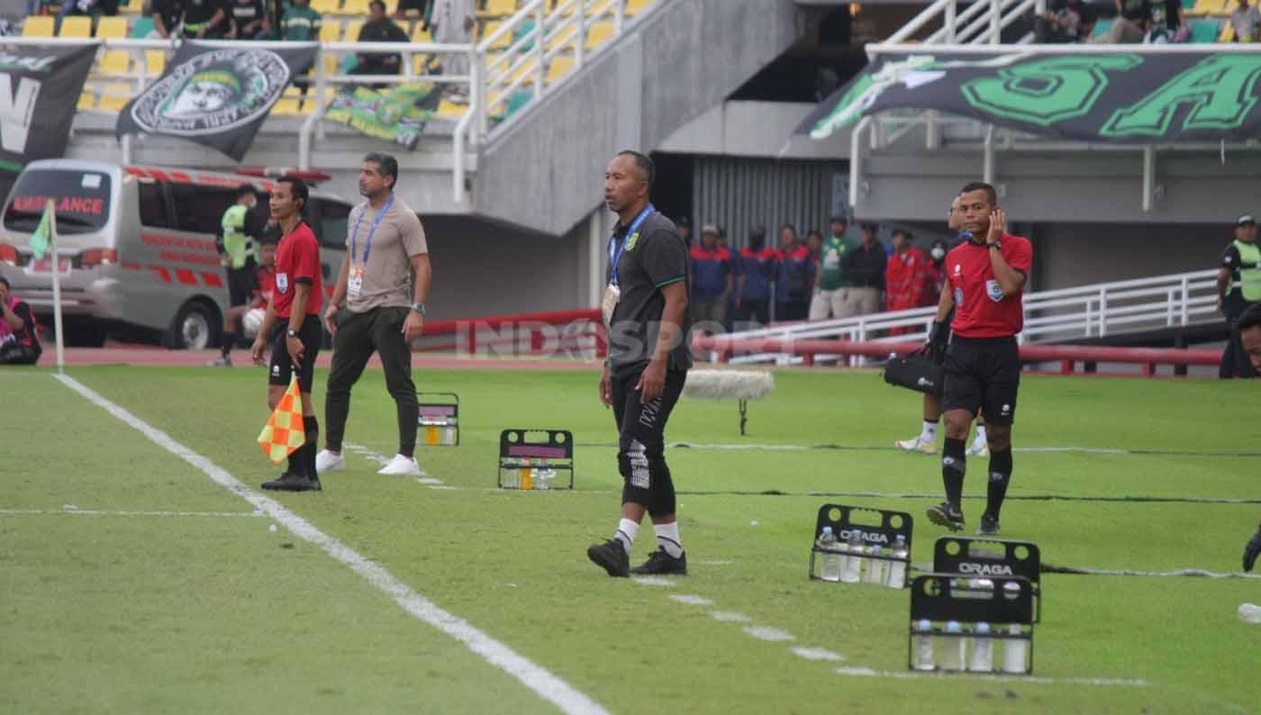 Pelatih karetaker Persebaya Uston Nawawi tegang melihat pemainnya dari pinggir lapangan pada pekan ketujuh laga Liga 1 di Stadion Gelora Bung Tomo (Surabaya), Sabtu (12/08/23). (Foto: Fitra Herdian/INDOSPORT)