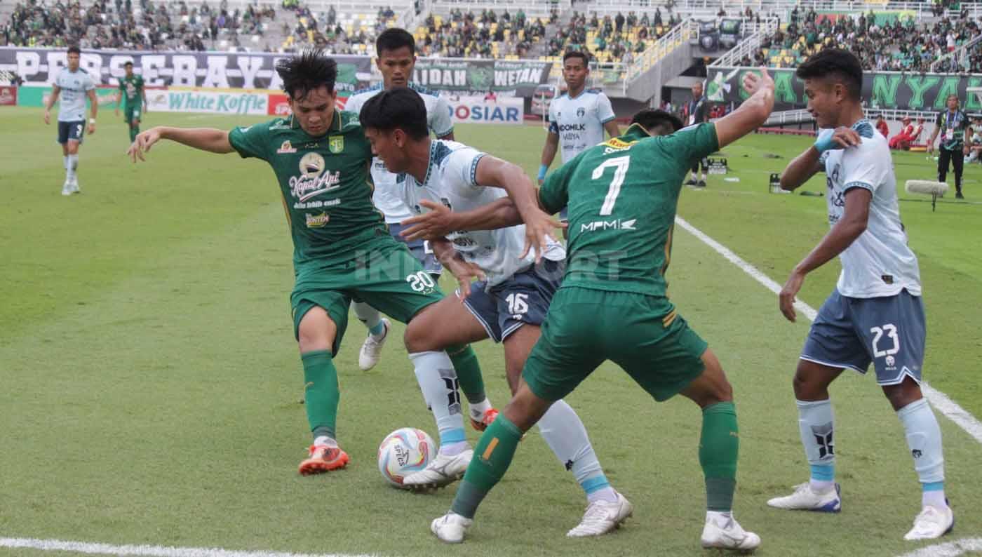 Pemain Persita Tangerang menghalangi pergerakan pemain Persebaya Surabaya pada pekan ketujuh laga Liga 1 di Stadion Gelora Bung Tomo (Surabaya), Sabtu (12/08/23). (Foto: Fitra Herdian/INDOSPORT)