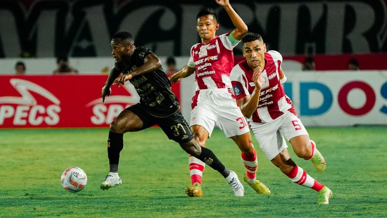 Dua bek Persis Solo berjibaku menghentikan penyerang Bali United, Privat Mbarga. (Foto: Bali United)