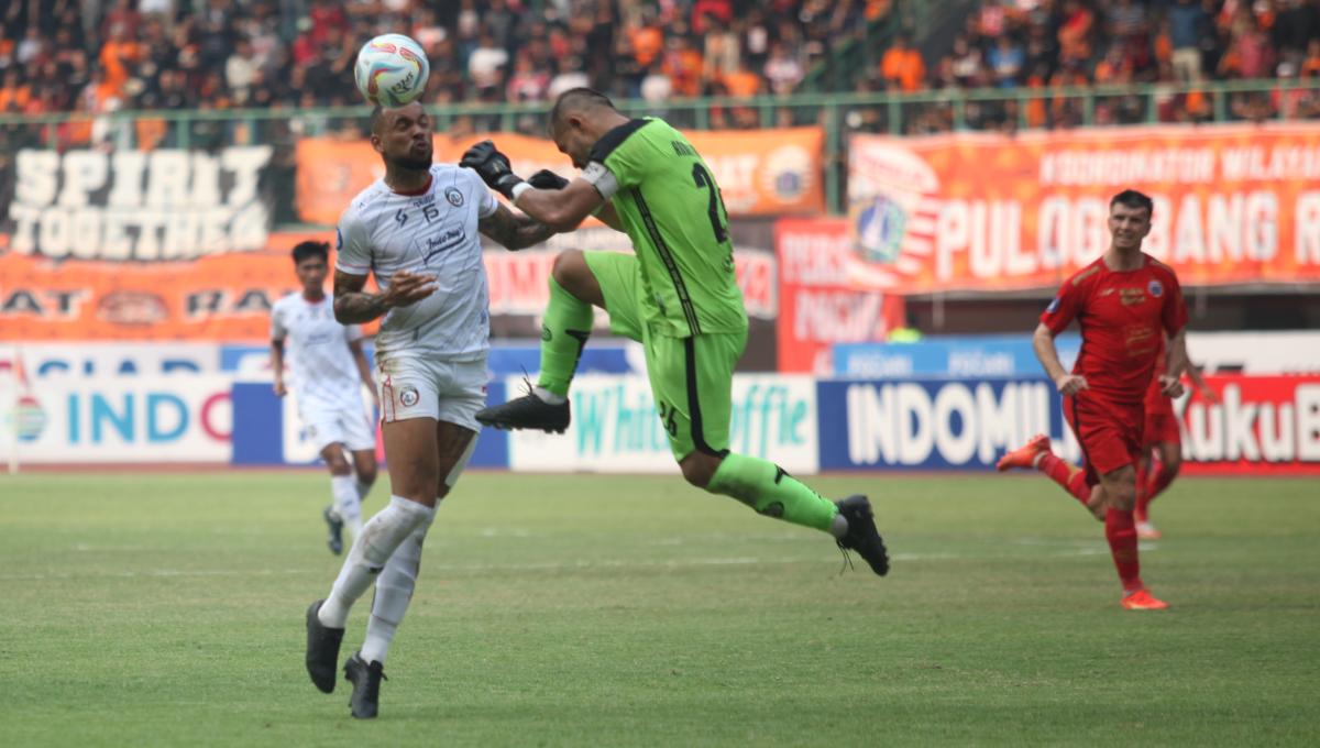 Kiper Persija, Andritany Ardhiyasa mencoba menghadang pergerakan striker Arema FC, Gustavo Almeida pada laga pekan kesembilan Liga 1 2023/2024 di stadion Patriot Bekasi, Minggu (20/08/23).