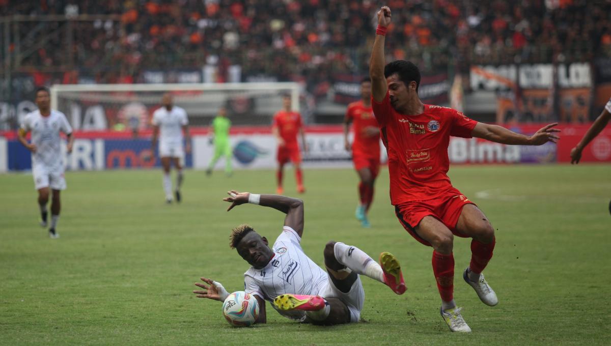 Striker Persija, Aji Kusuma (kanan) gagal melewati hadangan bek Arema FC pada laga pekan kesembilan Liga 1 2023/2024 di stadion Patriot Bekasi, Minggu (20/08/23).