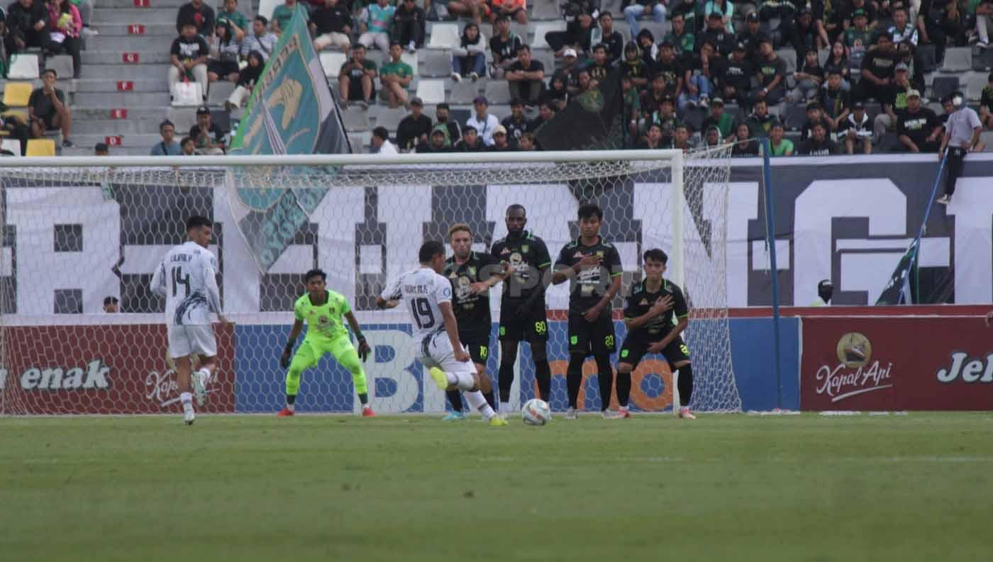 Pemain Borneo FC Adam Alis mengeksekusi tendangan bebas yang berhasil diantisipasi kiper Persebaya Surabaya Andika Ramadhani pada pekan ke 11 laga Liga 1 di Stadion Gelora Bung Tomo (Surabaya), Minggu (03/09/23). (Foto: Fitra Herdian/INDOSPORT)