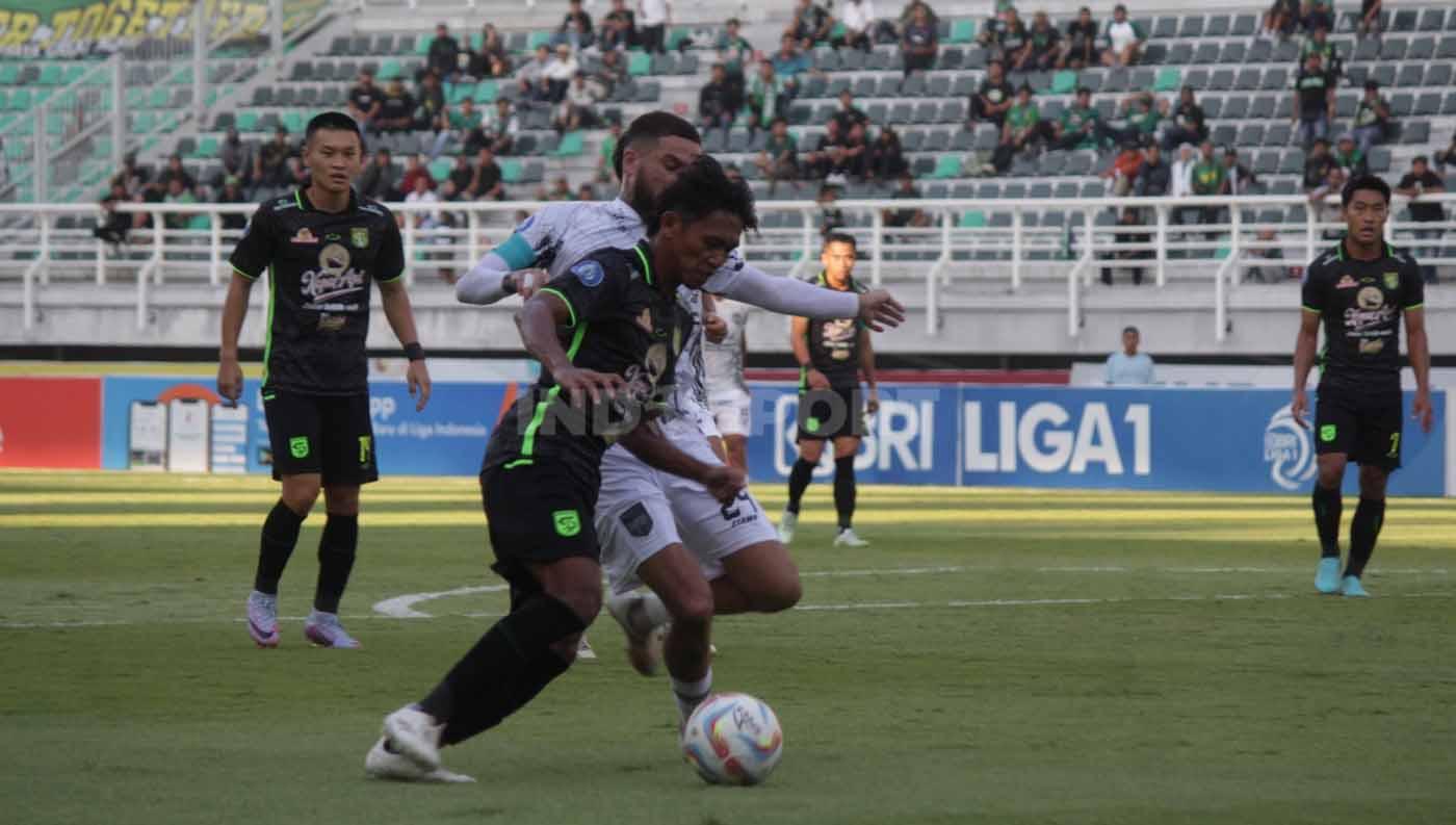 Pemain Persebaya Arif Catur dijaga ketat pemain Borneo Diego Michiels dekat dari kotak penalti pada pekan ke 11 laga Liga 1 di Stadion Gelora Bung Tomo (Surabaya), Minggu (03/09/23). (Foto: Fitra Herdian/INDOSPORT)