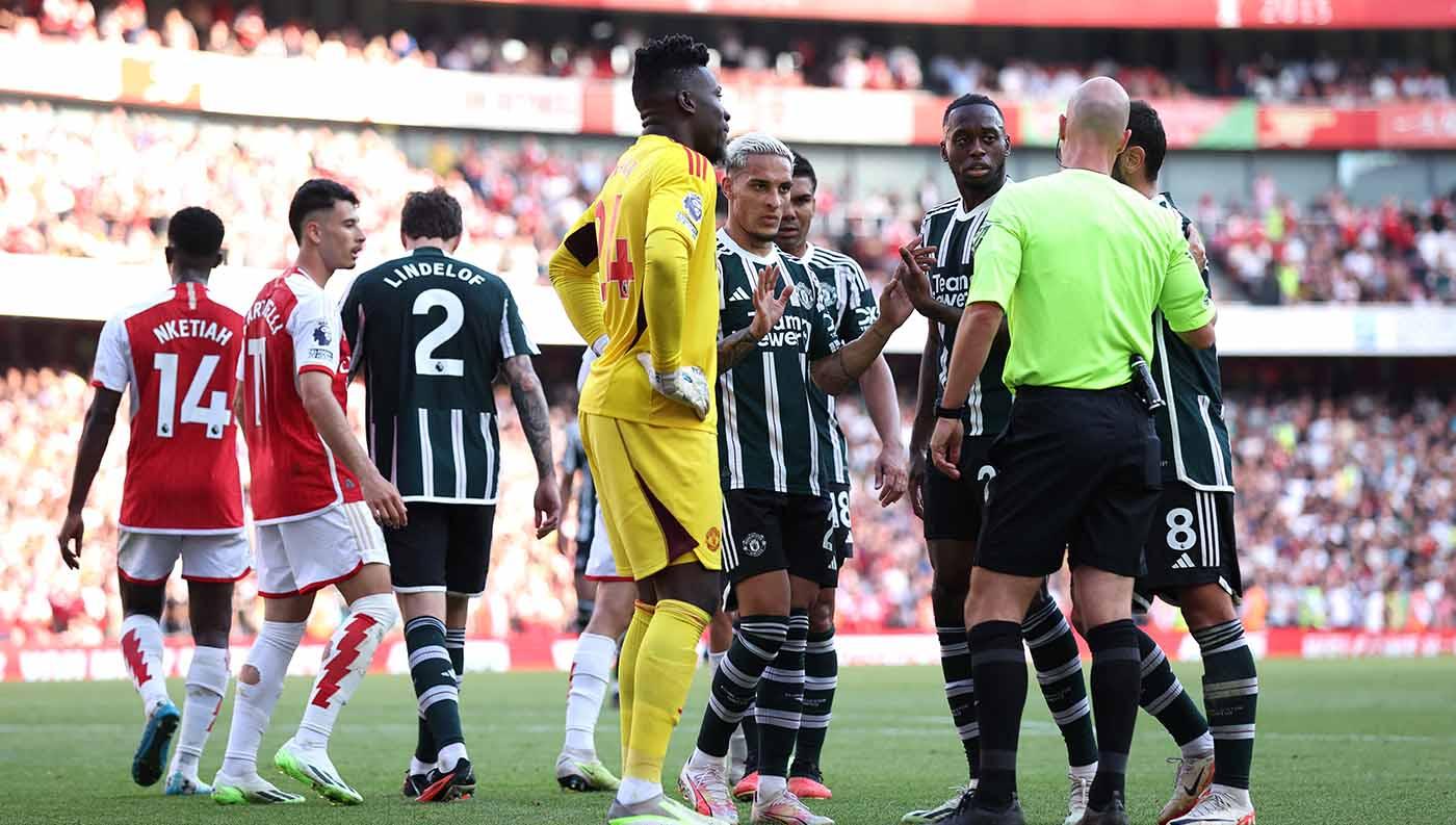 Kiper Manchester United Andre Onana bersama rekan satu timnya memprotes wasit Anthony Taylor saat penalti diberikan kepada Arsenal pada laga Liga Inggris di Stadion Emirates, London, Senin (04/09/23). (Foto: REUTERS/David Klein)