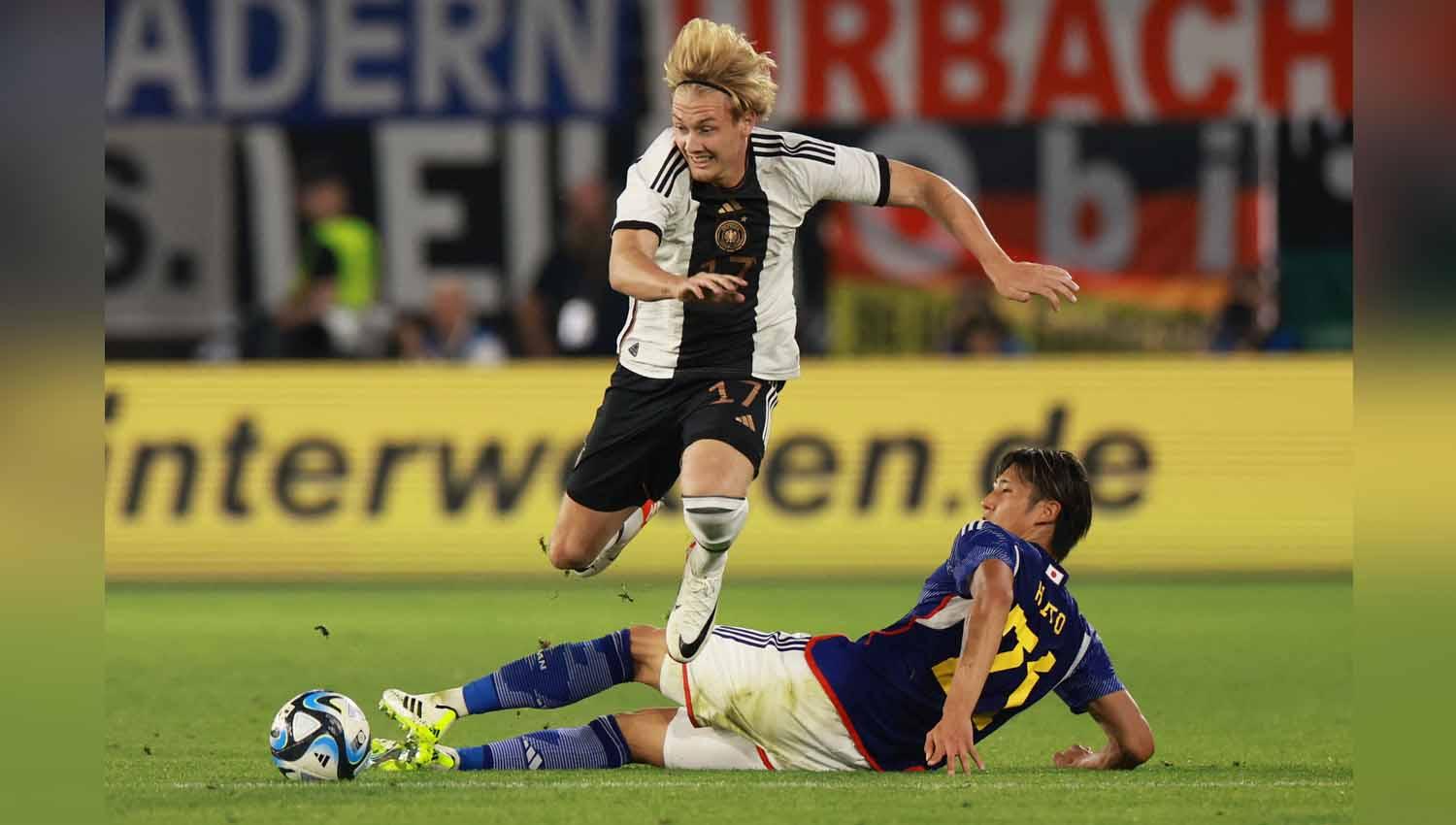 Pemain Jerman Julian Brandt berebut bola dengan pemain Jepang Hiroki Ito. (Foto: REUTERS/Lisi Niesner)