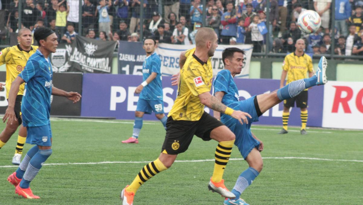 Pemain Persib All Stars membuang bola yang mengarah ke arah pemain Borussia Dortmund pada friendly match di stadion Siliwangi, Bandung, Minggu (10/09/23).