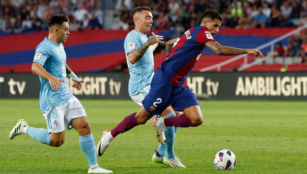 Aksi Joao Cancelo (kanan) melewati Iago Aspas (kiri) di laga Barcelona vs Celta Vigo (23/09/23). (Foto: REUTERS/Albert Gea)