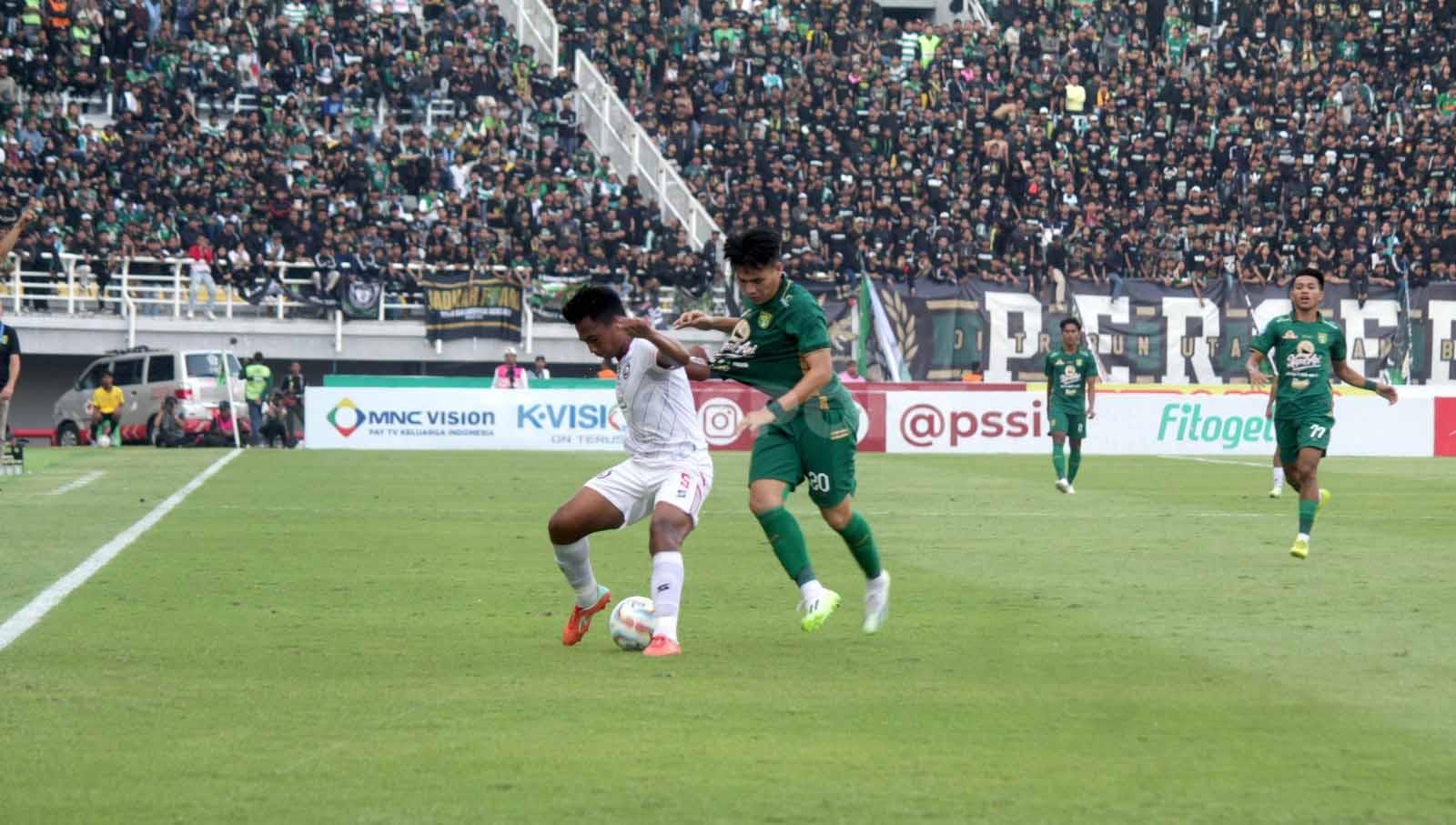 Pemain Persebaya Surabaya Wildan Ramdhani berduel dengan Pemain Arema FC Syaeful Anwar dalam laga pekan ke-13 Liga 1 2023-2024 di Stadion Gelora Bung Tomo, Surabaya. (Foto: Fitra Herdian/INDOSPORT)