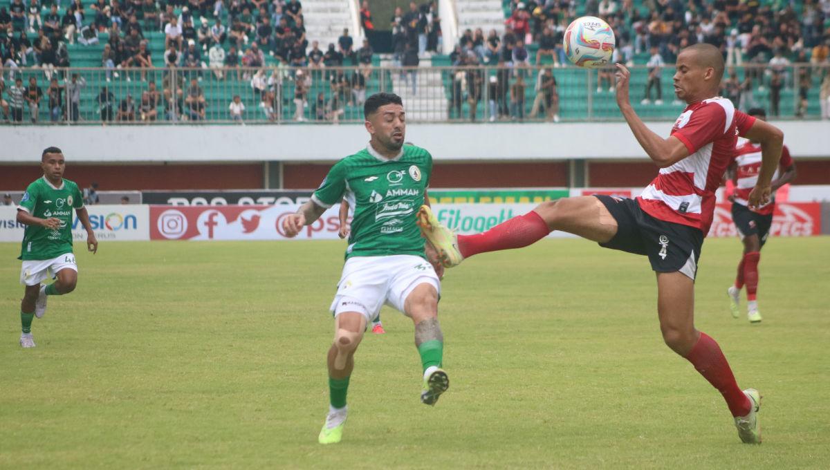 Bek Madura United, Cleberson, merebut bola yang dikuasai gelandang PSS, Jonathan Bustos, dalam laga pekan ke-13 Liga 1 2023-2024 di Stadion Maguwoharjo, Minggu (24/9/23).