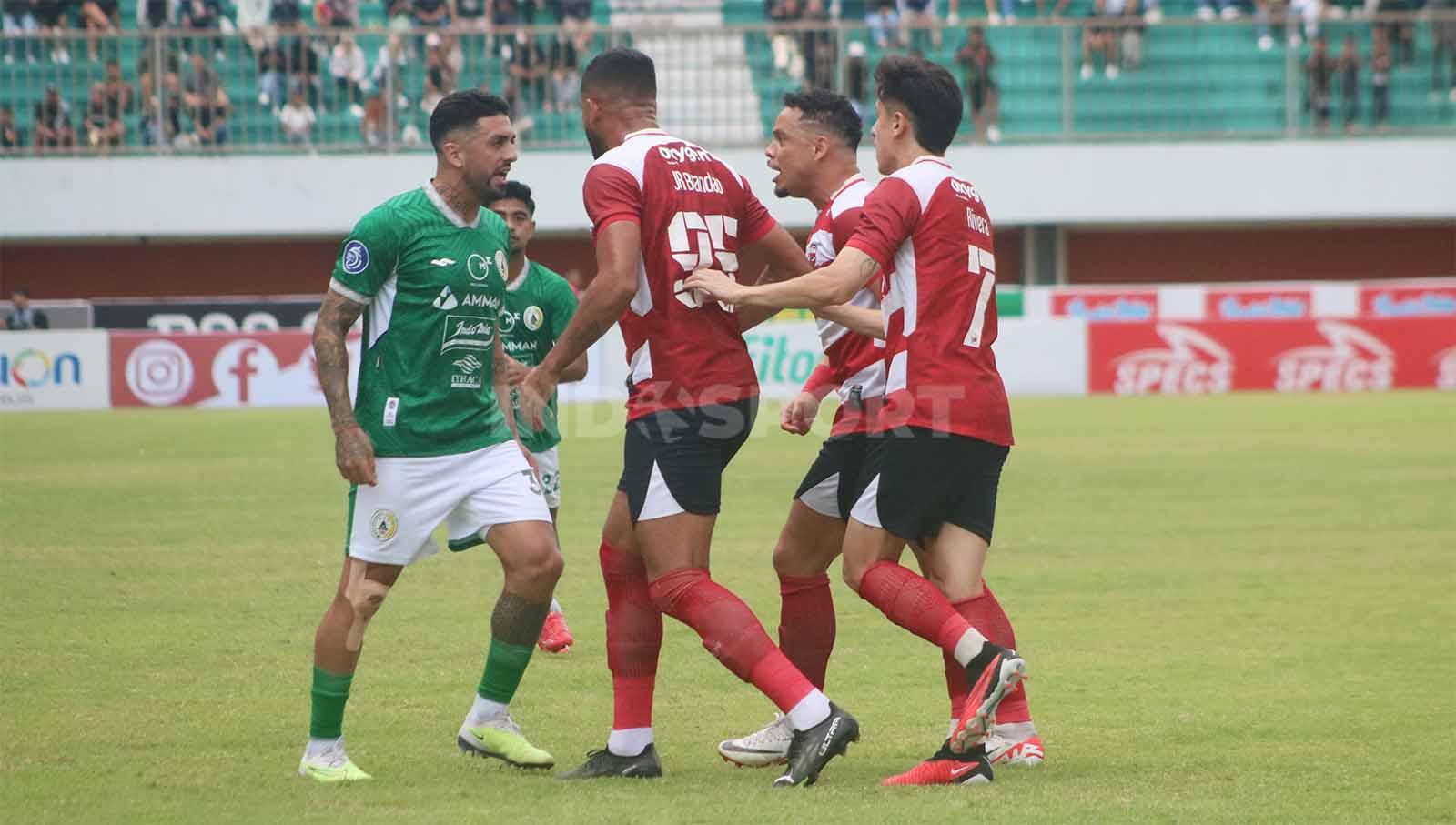 Para pemain Madura United memprotes keras gelandang PSS, Jonathan Bustos, yang tak langsung membuang bola setelah Yuda terkapar dalam laga pekan ke-13 Liga 1 2023-2024 di Stadion Maguwoharjo, Minggu (24/9/23).