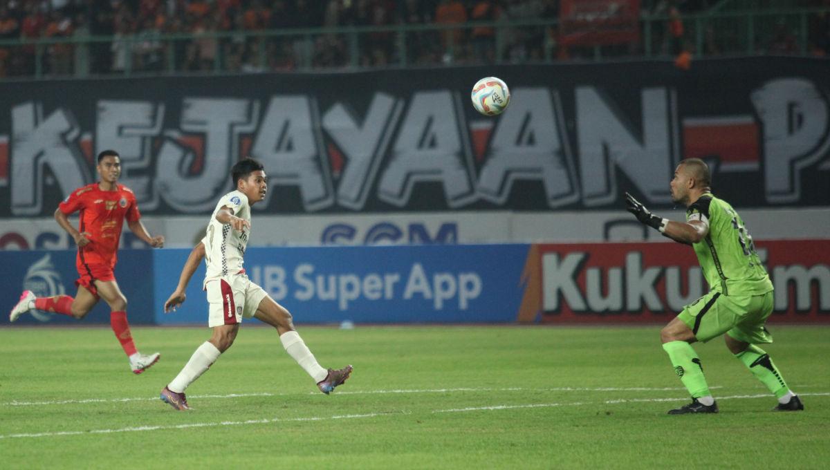 Pemain Bali United, Rahmat Arjuna saat berhasil melewati kiper Persija, Andritany Ardhiyasa pada laga pekan ke-13 Liga 1 2023/2024 di Stadion Patriot, Minggu (24/09/23).