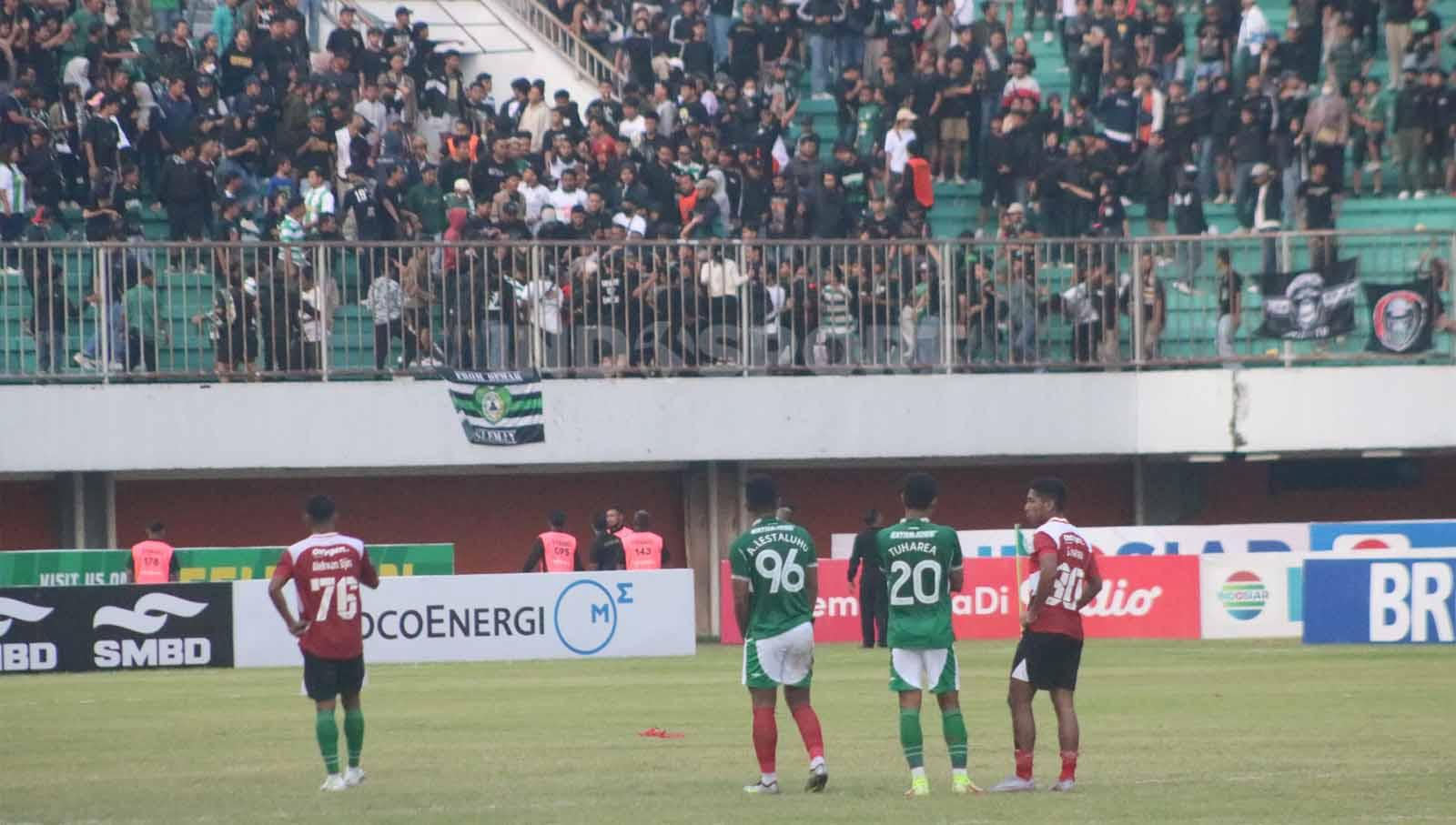 Para pemain PSS Sleman dan Madura United melihat keributan di tribun Utara Stadion Maguwoharjo usai laga pekan ke-13 Liga 1 2023-2024 di Stadion Maguwoharjo, Minggu (24/9/23).
