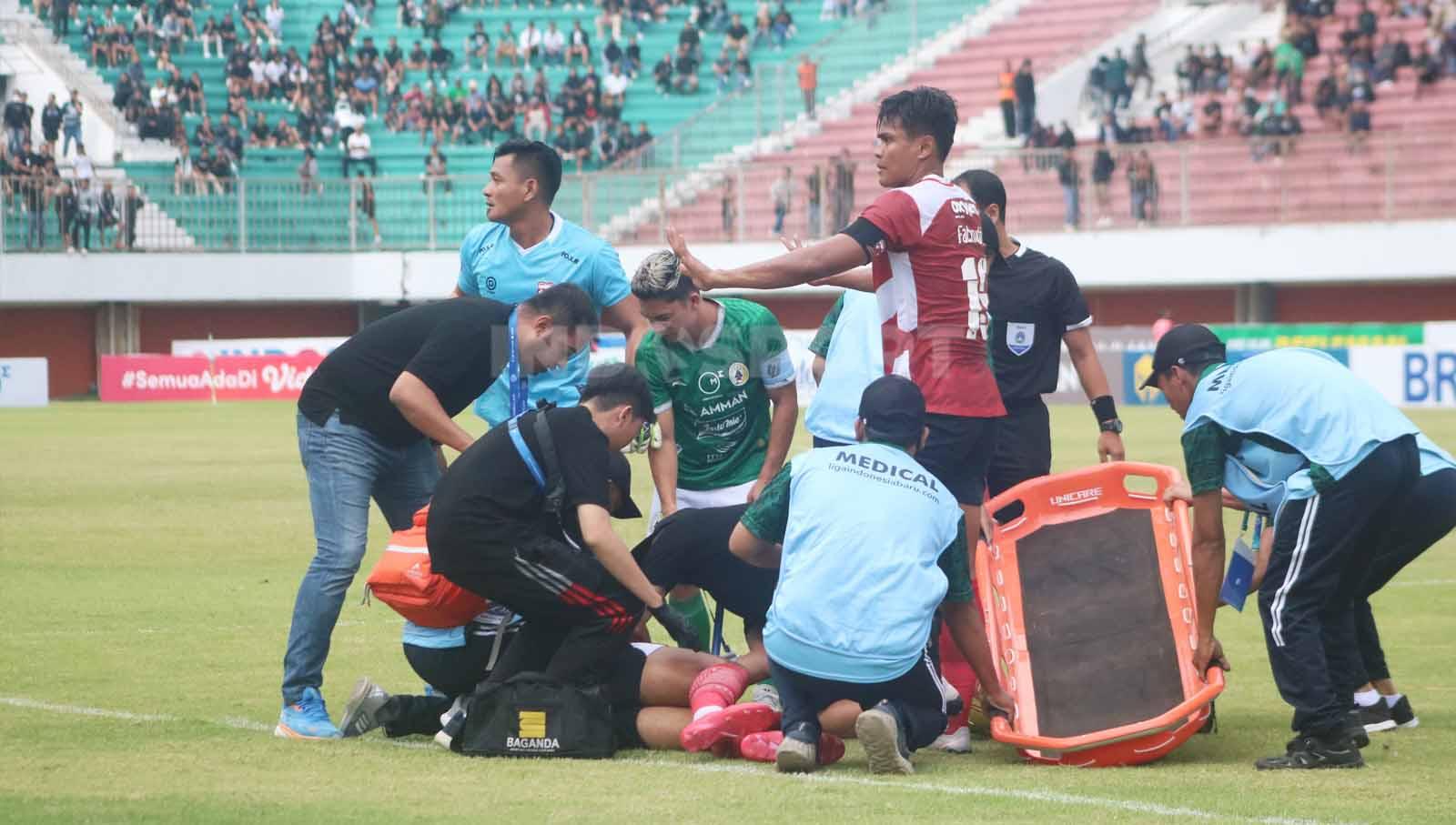 Dua kapten tim saat melihat proses penanganan medis terhadap pemain muda Madura United, Yuda, yang terkapar usai terkena tendangan keras Jonathan Bustos  dalam laga pekan ke-13 Liga 1 2023-2024 di Stadion Maguwoharjo, Minggu (24/9/23).