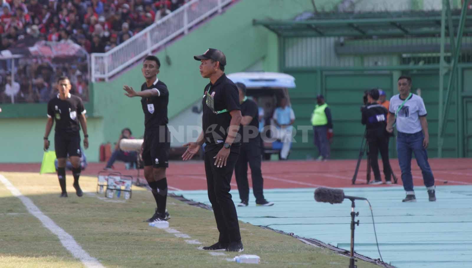 Pelatih Deltras FC Widodo C Putro berdiri menyaksikan timnya dari pinggir lapangan dalam laga Pegadaian Liga 2 2023-2024 di Stadion Gelora Delta Sidoarjo, Minggu (24/09/23).