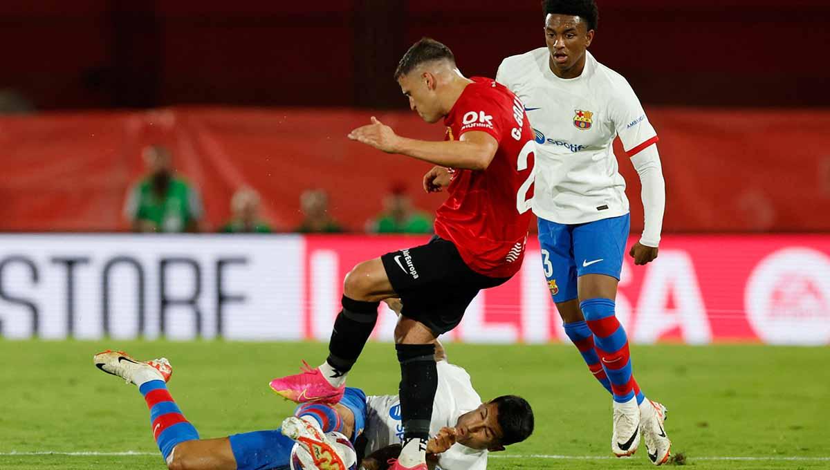 Situasi perebutan bola antara pemain RCD Mallorca vs Barcelona di Liga Spanyol.