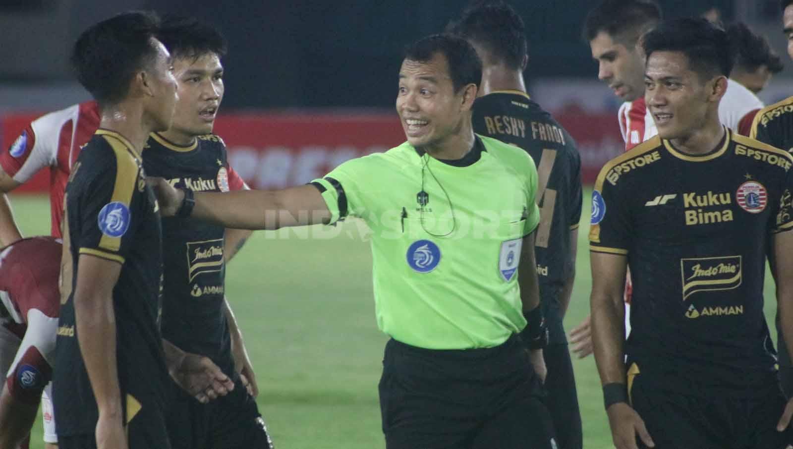 Wasit Nendi Rohaendi saat melayani protes pemain Persija Jakarta dalam laga pekan ke-14 Liga 1 2023-2024, Sabtu (30/9/23). (Foto: Nofik Lukman Hakim/INDOSPORT)