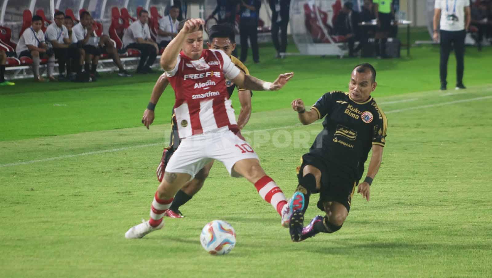 Winger Persija, Riko Simanjuntak, berusaha merebut bola yang dikuasai gelandang Persis Solo, Alexis Messidoro, dalam laga pekan ke-14 Liga 1 2023-2024, Sabtu (30/9/23). (Foto: Nofik Lukman Hakim/INDOSPORT)