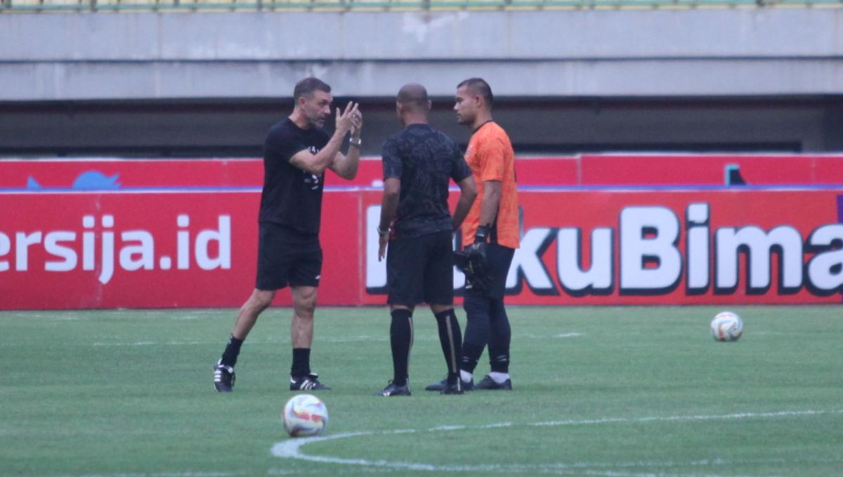 Pelatih Thomas Doll sedang memberi arahan kepada kiper Andritany Ardhiyasa yang belakangan mendapat kritik terkait penampilannya.