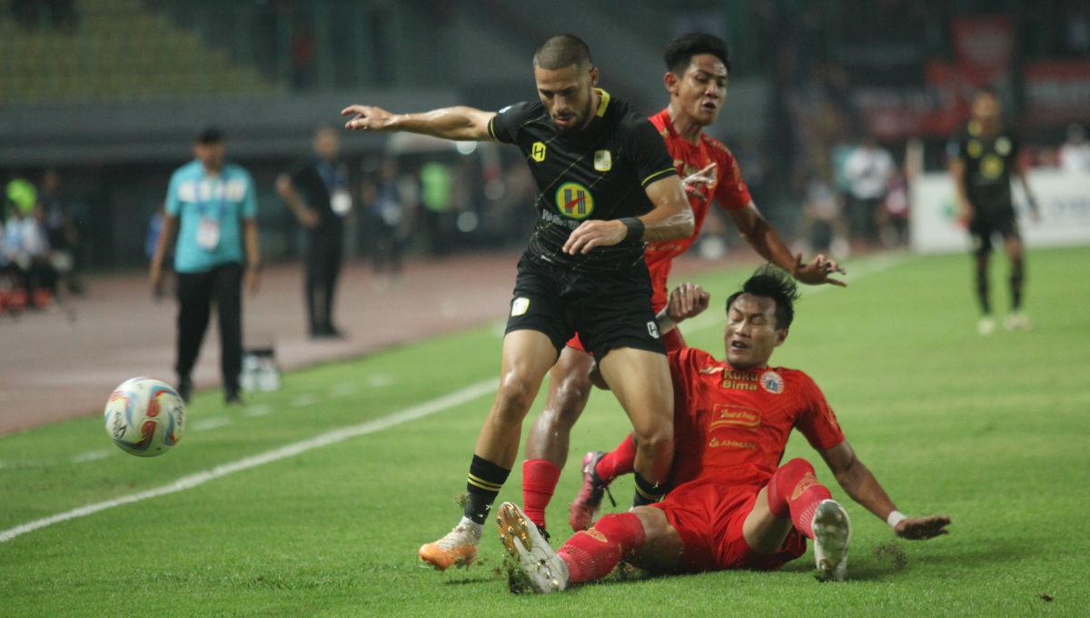 Bek Persija, Hansamu Yama melakukan tackle ke arah striker Barito, Mike Ott dalam laga pekan ke-15 Liga 1 2023/2024 di Stadion Patriot, Minggu (07/10/23).