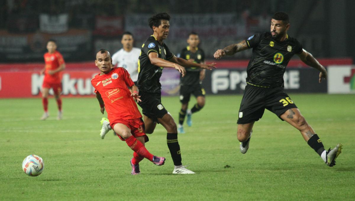 Aksi pemain Persija, Riko Simanjuntak dihadang dua pemain Barito dalam laga pekan ke-15 Liga 1 2023/2024 di Stadion Patriot, Minggu (07/10/23).