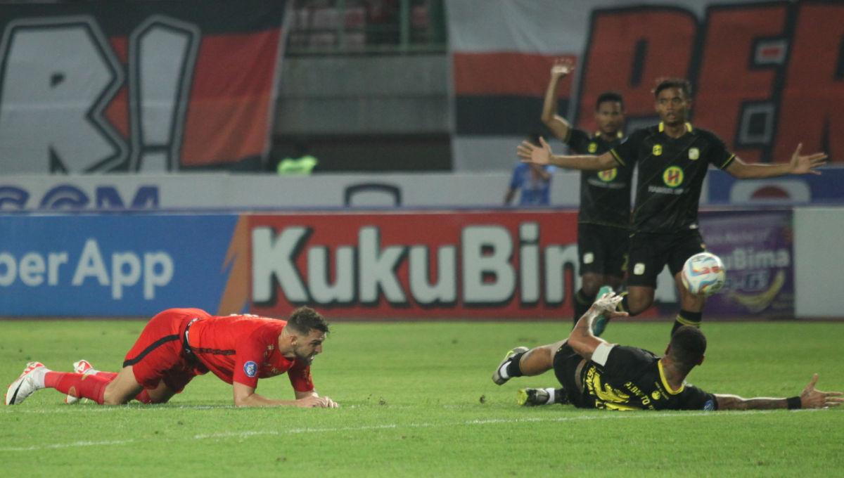 Striker Persija, Marko Simic terjatuh saat berduel dengan pemain Barito dalam laga pekan ke-15 Liga 1 2023/2024 di Stadion Patriot, Minggu (07/10/23).