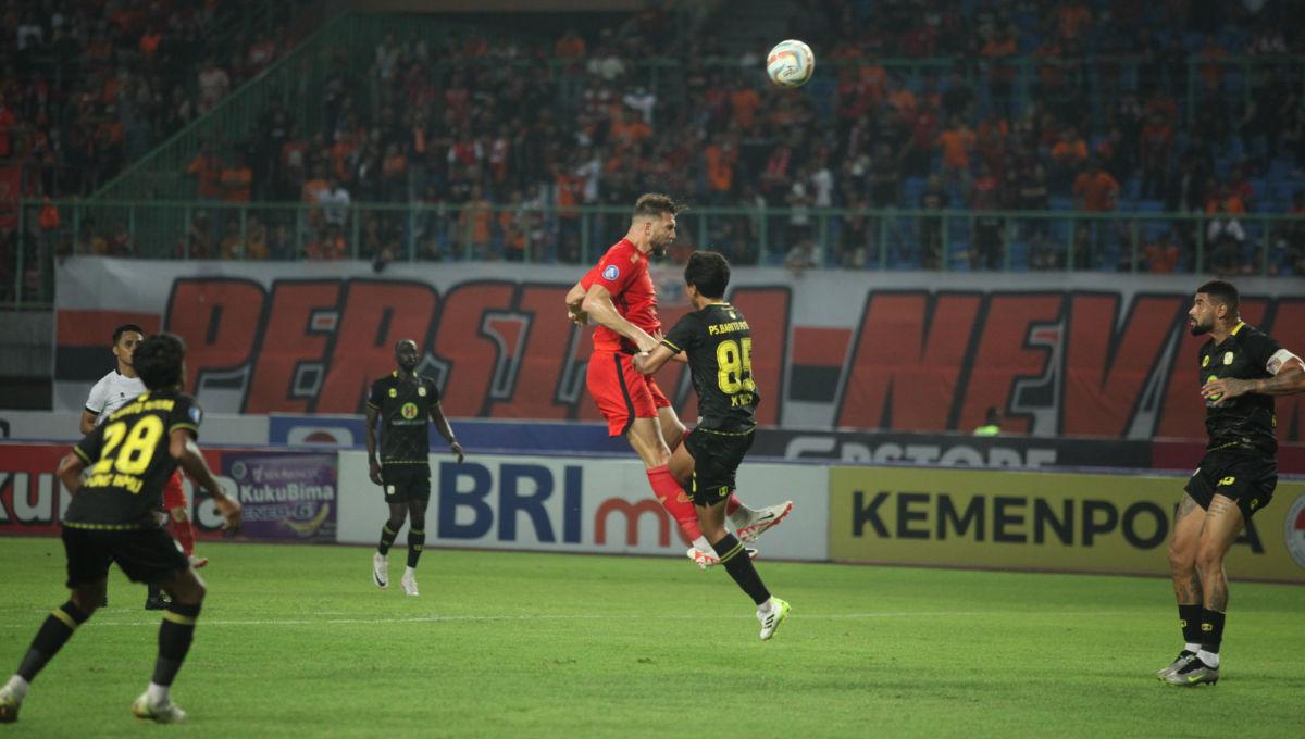 Duel udara striker Persija, Marko Simic dengan pemain Barito dalam laga pekan ke-15 Liga 1 2023/2024 di Stadion Patriot, Minggu (07/10/23).