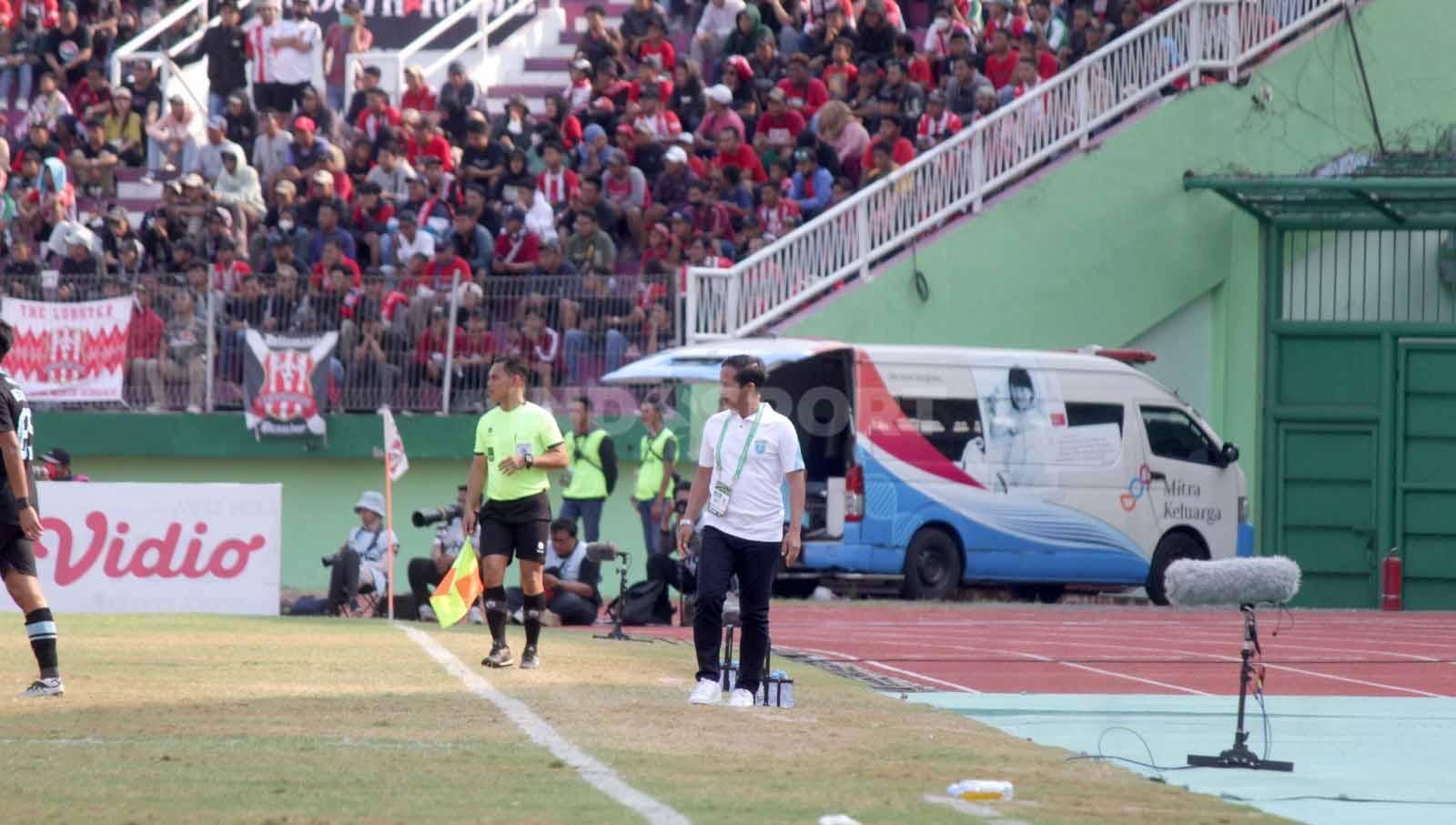 Pelatih Persela Lamongan, Djadjang Nurdjaman, memberikan instruksi ke pemainnya dari pinggir lapangan. Foto: Fitra Herdian/INDOSPORT.