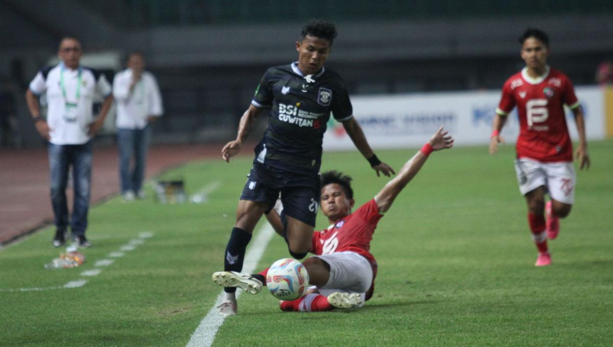 Pemain FC Bekasi City melakukan sliding tackle ke arah pemain Perserang dalam laga lanjutan Liga 2 2023/2024 di Stadion Patriot, Minggu (15/10/23).