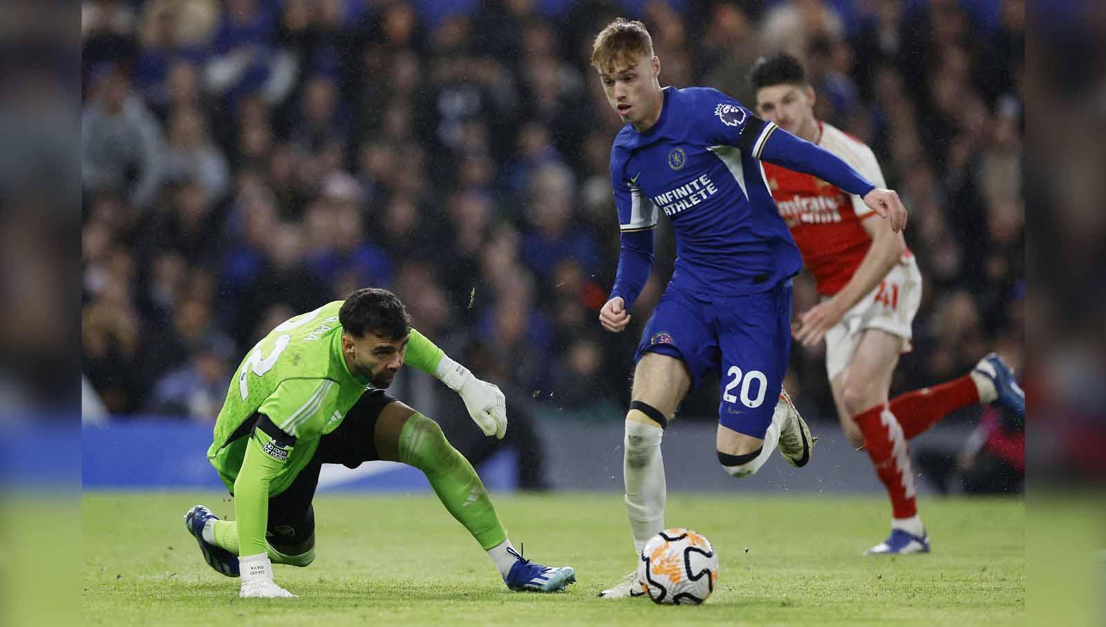 Pemain Chelsea, Cole Palmer mendapat perlawanan dari kiper Arsenal David Raya pada laga Liga Inggris. (Foto: Reuters/Peter Cziborra)