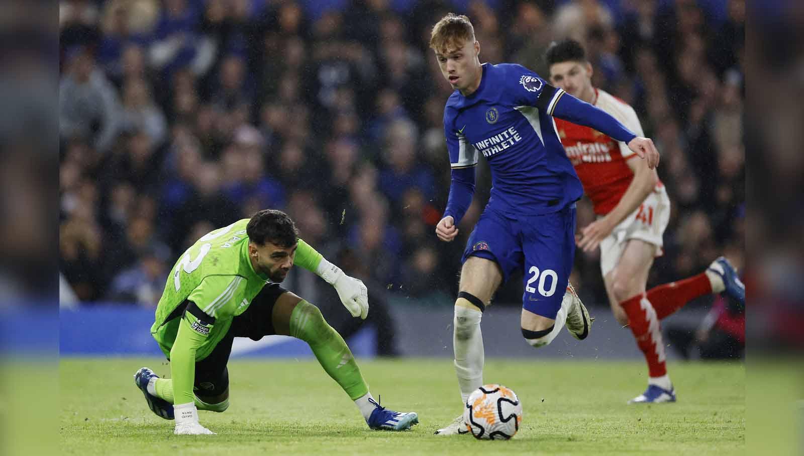 Pemain Chelsea, Cole Palmer mendapat perlawanan dari kiper Arsenal David Raya pada laga Liga Inggris. (Foto: Reuters/Peter Cziborra) - INDOSPORT