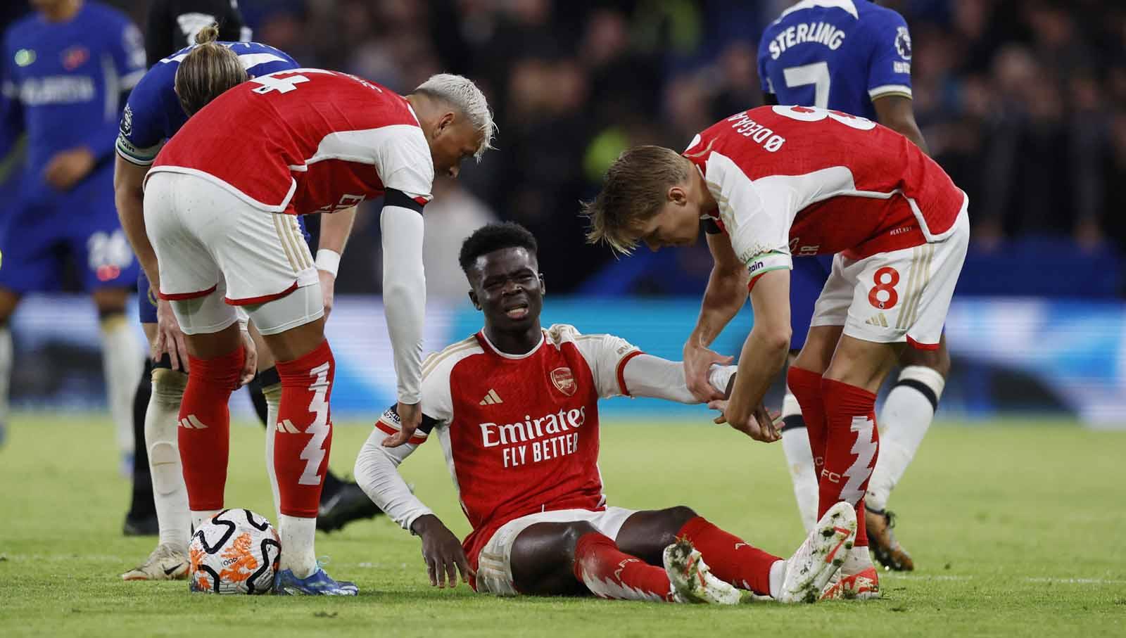Pemain Arsenal Bukayo Saka terlihat kesakitan saat cedera pada laga Liga Inggris. (Foto: Reuters/Peter Cziborra)