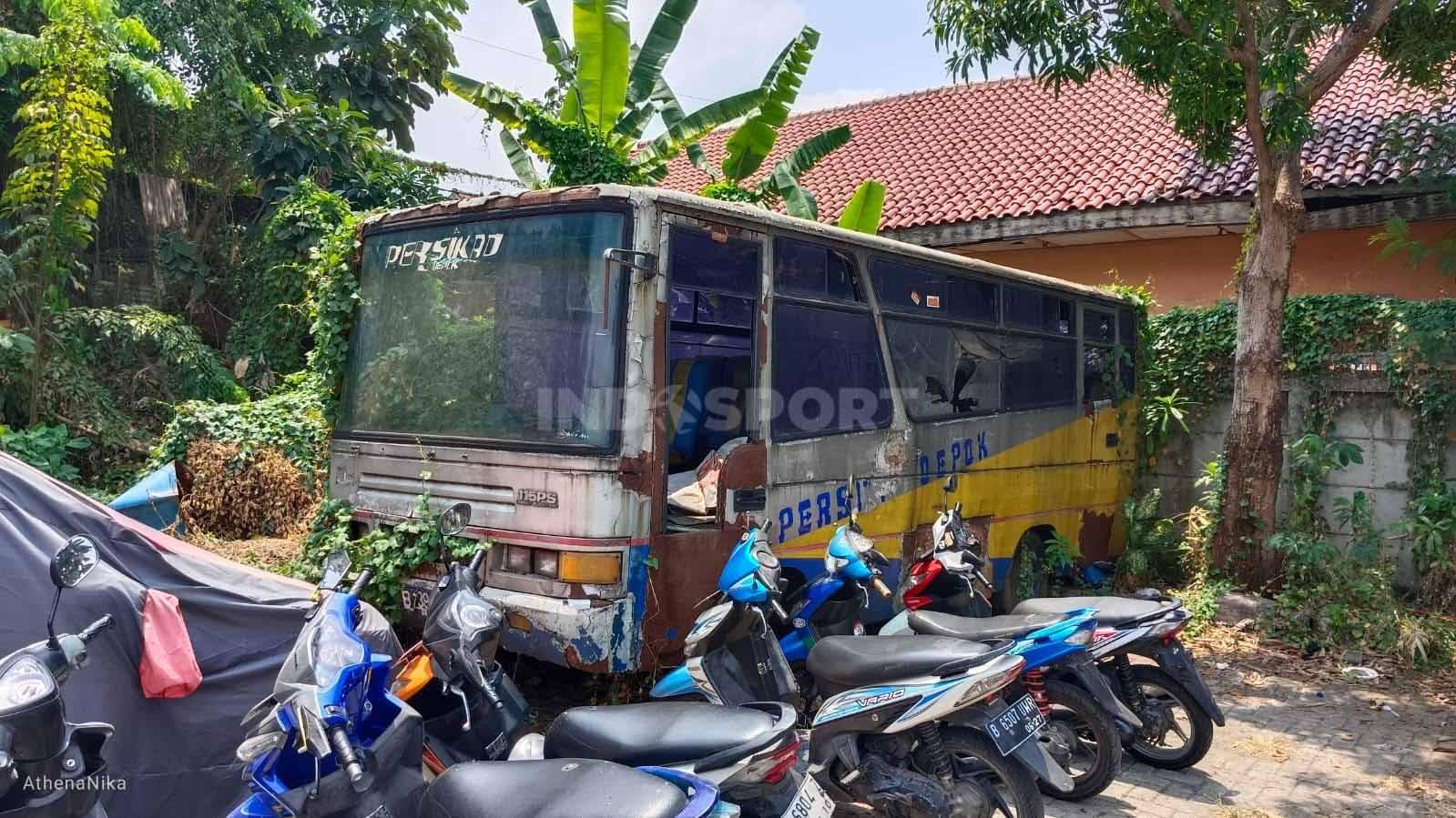 Bus yang dulu digunakan sebagai transportasi pemain Persikad Depok teronggok di parkiran motor Stadion Merpati Depok, Kamis (26/10/23). (Foto: Indra Citra Sena/INDOSPORT)