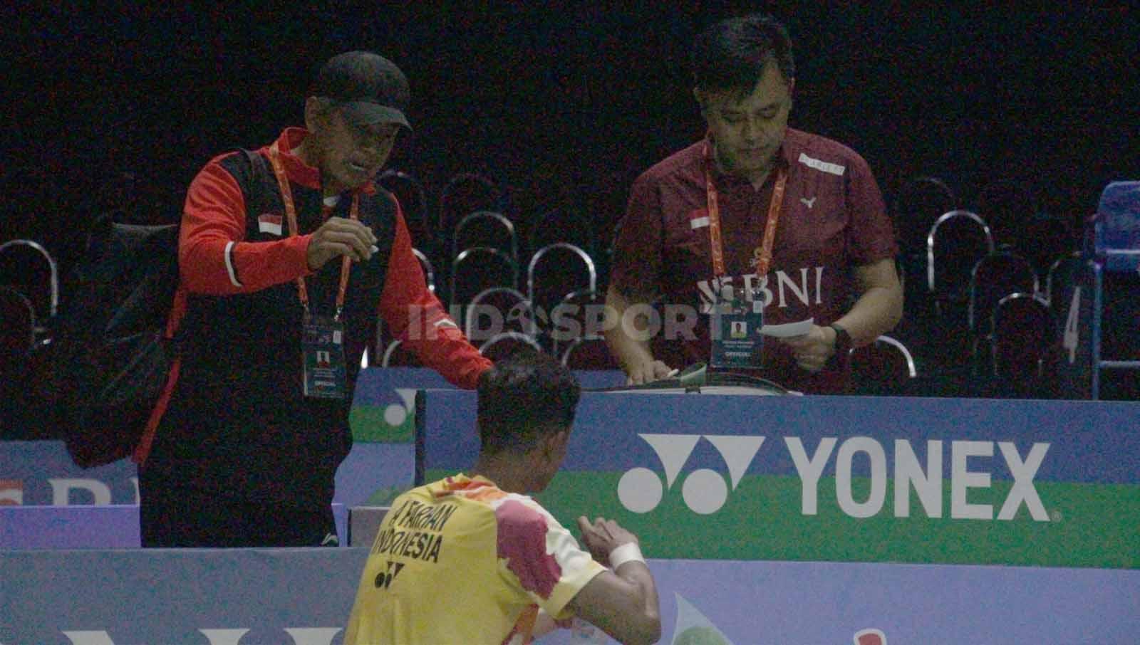 Alwi Farhan mendapatkan arahan dari dua pelatih saat set kedua di babak 16 besar Indonesia Masters II 2023. (Foto: Fitra Herdian/INDOSPORT)