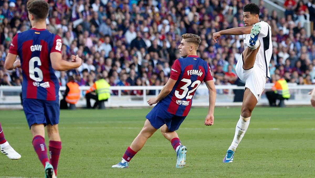Jude Bellingham melepaskan tembakan berbuah gol di laga Barcelona vs Real Madrid. (Foto: REUTERS/Albert Gea)