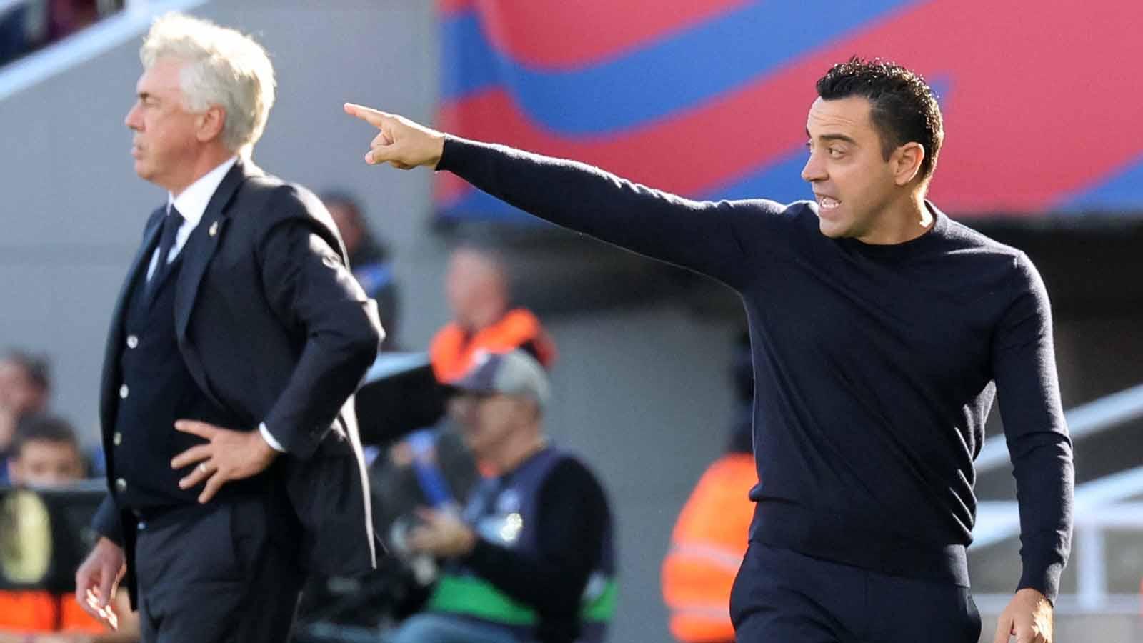 Pelatih Barcelona Xavi bereaksi dan pelatih Real Madrid arlo Ancelotti pada laga LaLiga Spanyol di Stadion Olímpic Lluís Companys (Barcelona), Sabtu (28/10/23). (Foto: REUTERS/Nacho Doce)