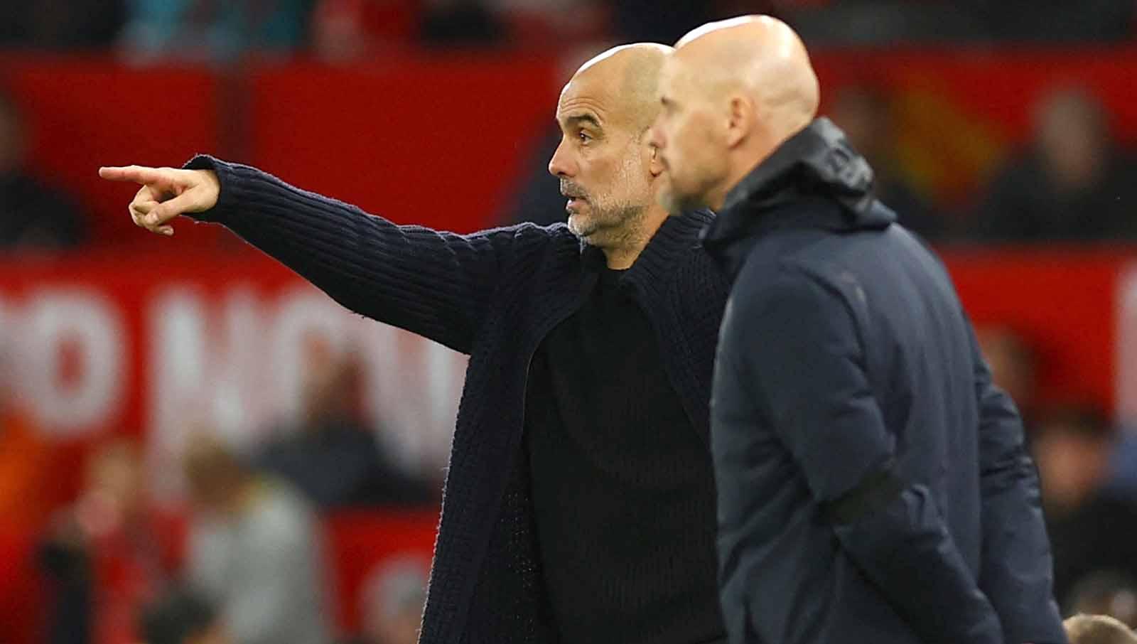 Dari pinggir lapangan, Pep Guardiola dan Erik ten Hag tetap berinteraksi satu sama lain meski mereka musuh di pertandingan. Foto: REUTERS/Molly Darlington.