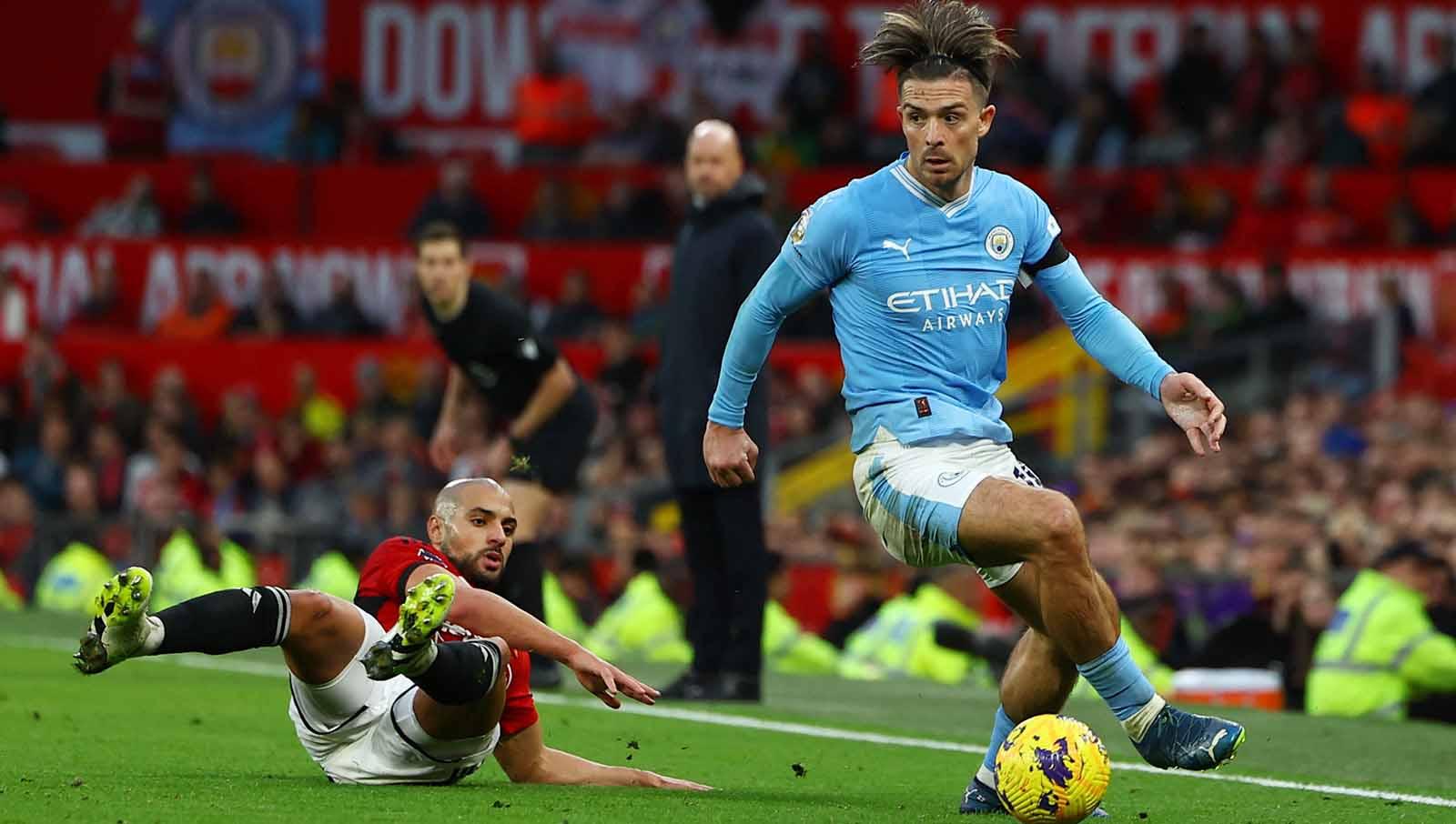 Sofyan Amrabat berusaha menghentikan pergerakan pemain Manchester City, Jack Grealish. Foto: REUTERS/Molly Darlington.