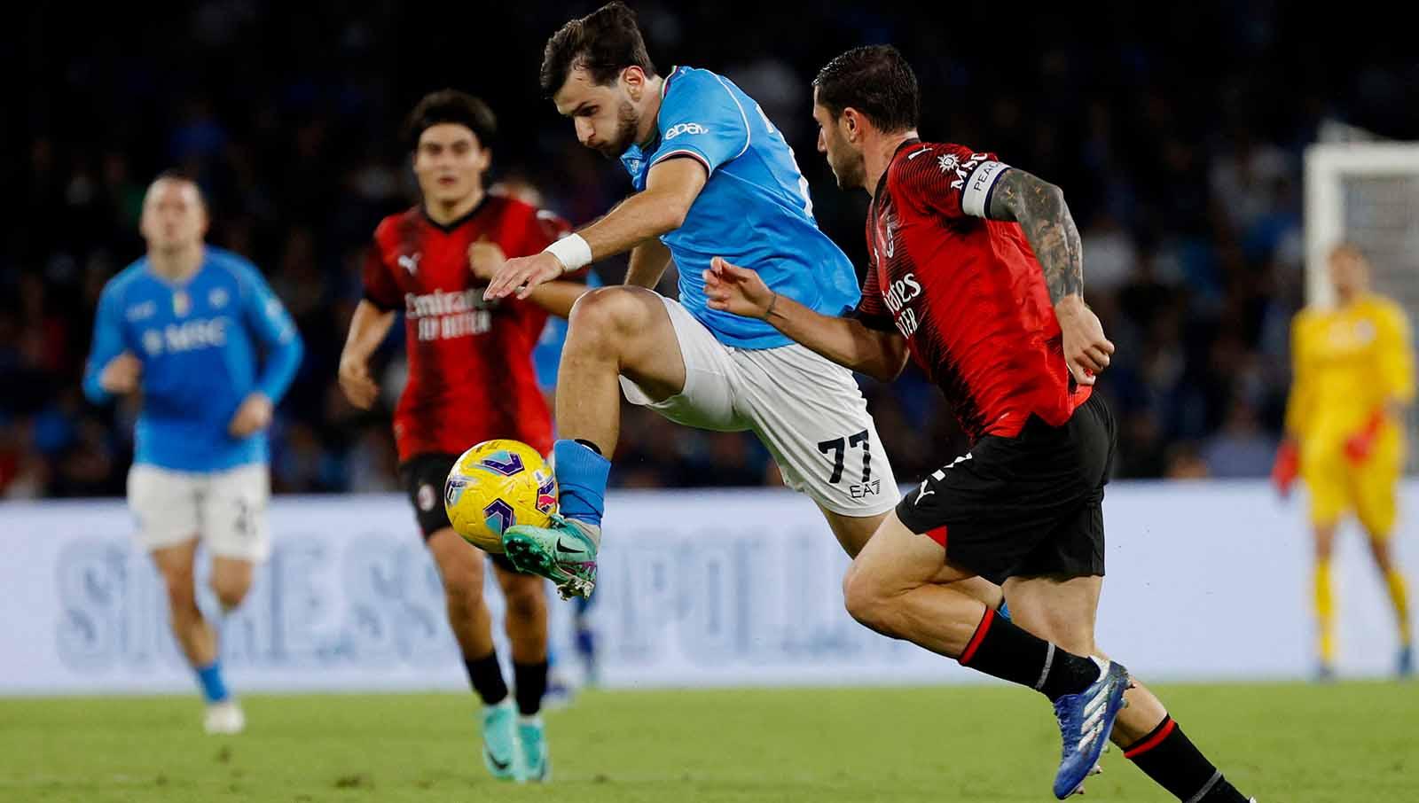 Pemain Napoli Khvicha Kvaratskhelia mencoba menghindar dari tekanan pemaon AC Milan Davide Calabria pada laga Serie A Italia. (Foto: REUTERS/Ciro De Luca)