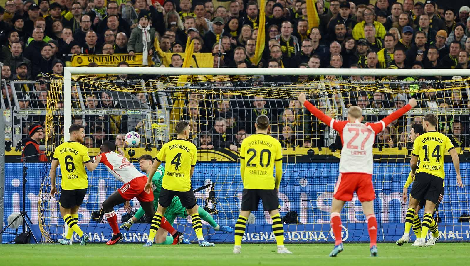 Pemain Bayern Munchen Dayot Upamecano usai mencetak gol pertama melewati kiper Borussia Dortmund Gregor Kobel pada laga Bundesliga Jerman di Stadion Signal Iduna Park. (Foto: REUTERS/Wolfgang Rattay)