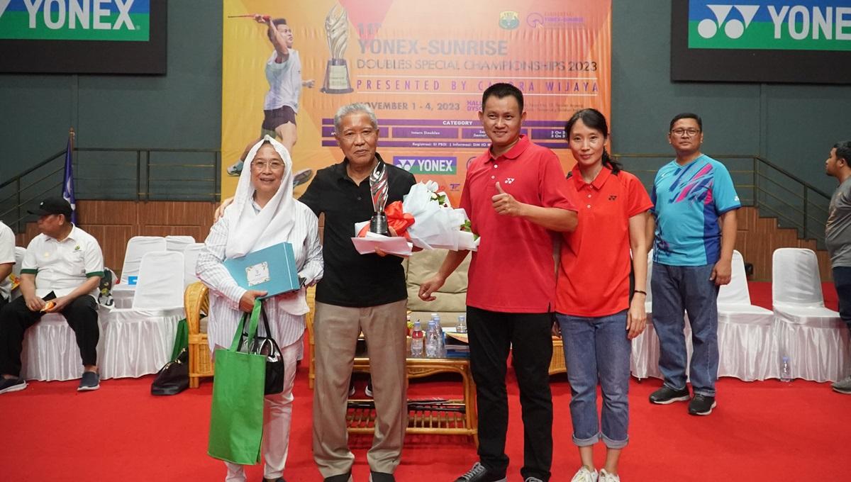 Legenda bulutangkis, Candra Wijaya (tengah), menyerahkan penghargaan kepada Atik Jauhari, Rabu (1/11/23). - INDOSPORT