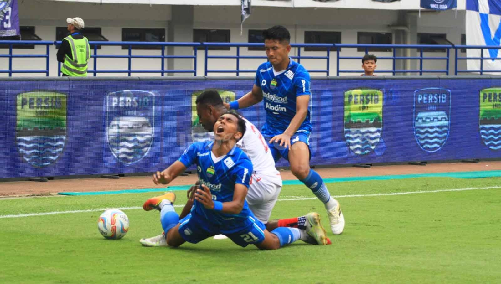 Winger Persib, Frets Butuan terjatuh saat berebut bola dengan pemain Arema FC, pada pertandingan Liga 1 2023-2024 di Stadion GBLA, Kota Bandung, Rabu (08/11/23).