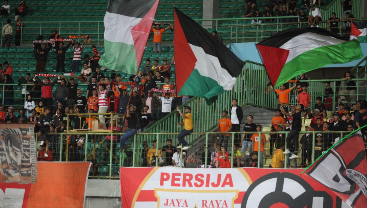 Suporter Jakmani mengibarkan bendera Palestina pada laga pekan ke-19 Liga 1 2023/2024 antara Persija vs Persikabo 1973 di Stadion Patriot, Kamis (09/11/23).