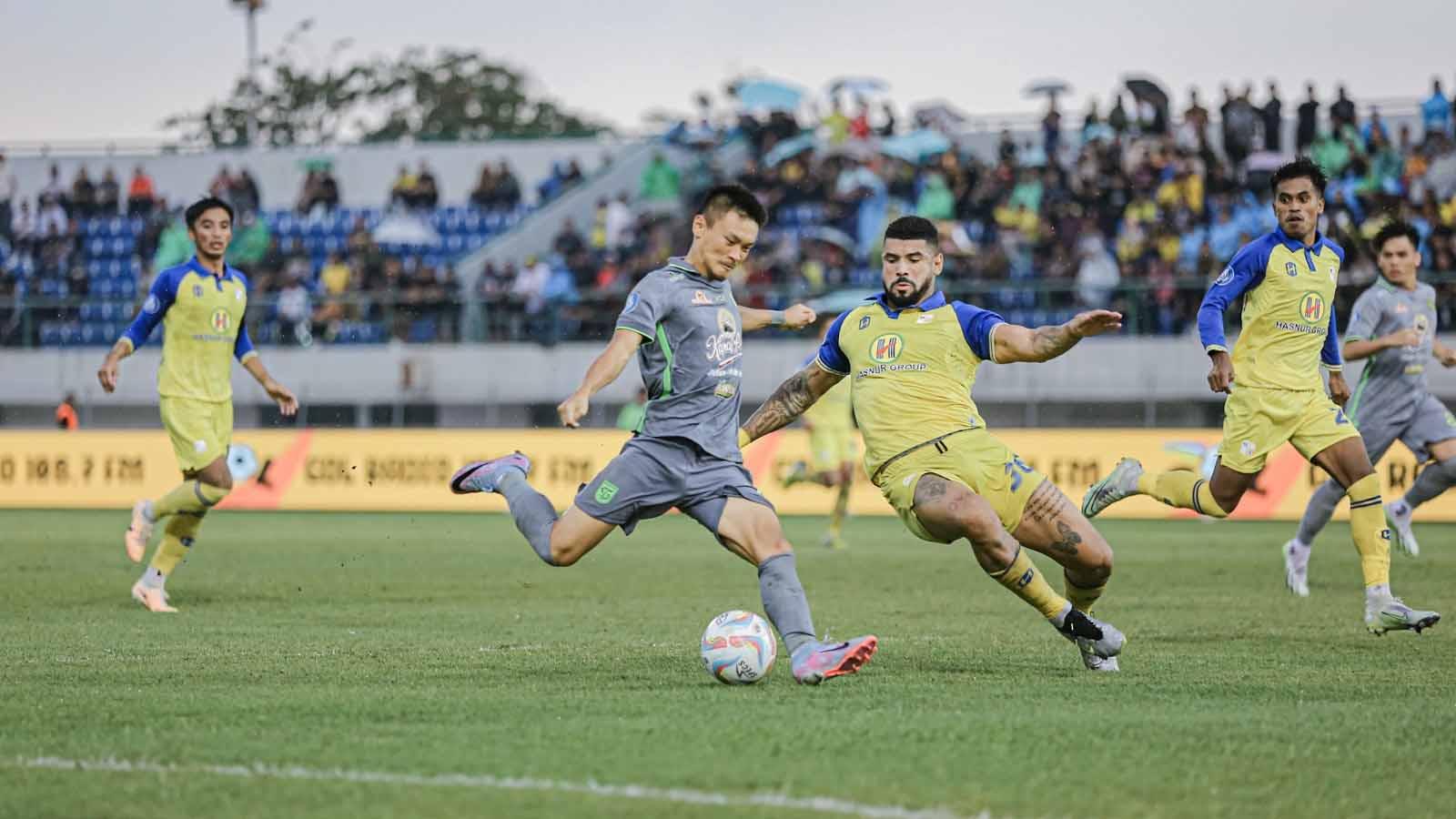 Tendangan keras pemain Persebaya Sho Yamamoto ditahan oleh pemain Barito Putera Renan da Silva Alves pada laga Liga 1 di Stadion Demang Lehman, Kamis (09/11/23). (Foto: MO Persebaya Surabaya)