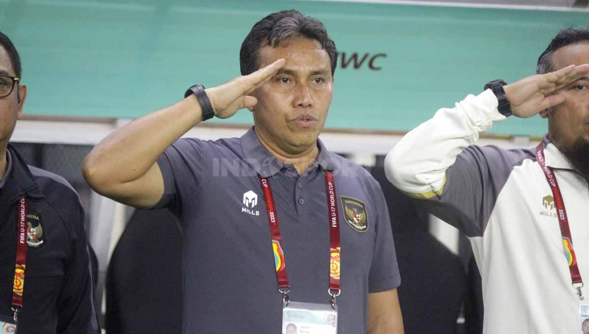 Pelatih Indonesia U-17 Bima Sakti khidmat menyanyikan lagu Indonesia Raya pada laga Timnas Indonesia U-17 vs Ekuador U-17 Piala Dunia U-17 di Stadion GBT, Jumat (10/11/23). (Foto: Fitra Herdian/INDOSPORT) - INDOSPORT