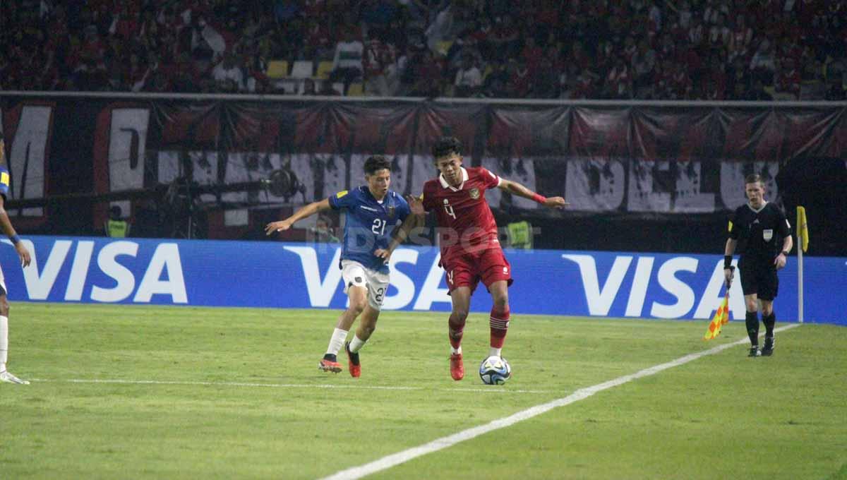 Pemain Timnas Indonesia U-17 Hanif Ramadhan dikawal ketat pemain Ekuador U-17 Santiago Sanchez pada laga Piala Dunia U-17 di Stadion GBT, Jumat (10/11/23). (Foto: Fitra Herdian/INDOSPORT)