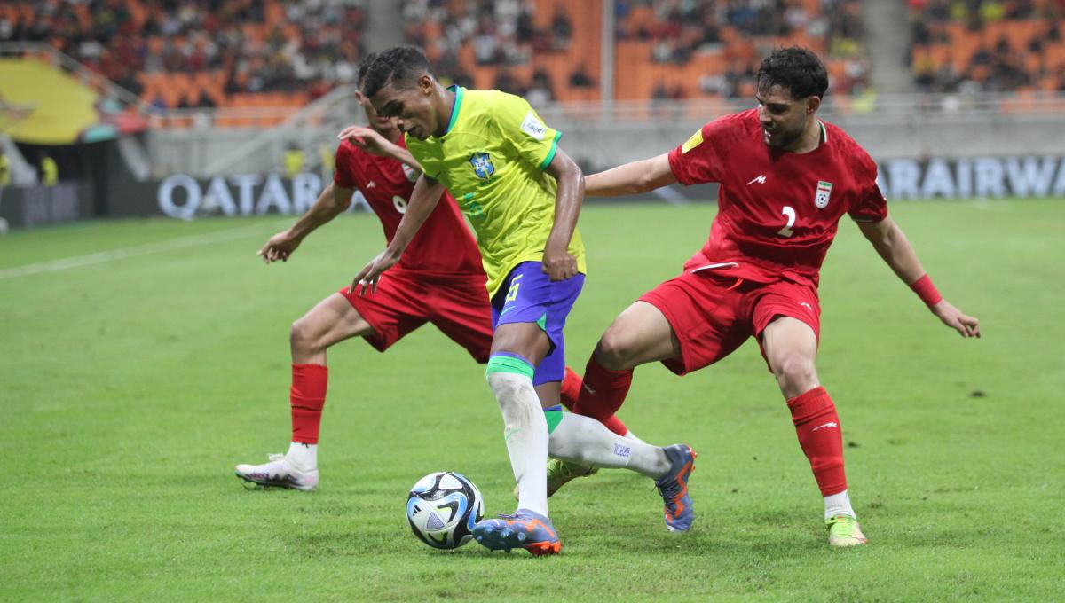 Dua pemain Iran menjaga ketat pemain Brasil pada laga fase grup C Piala Dunia U-17 di Stadion JIS, Sabtu (11/11/23).