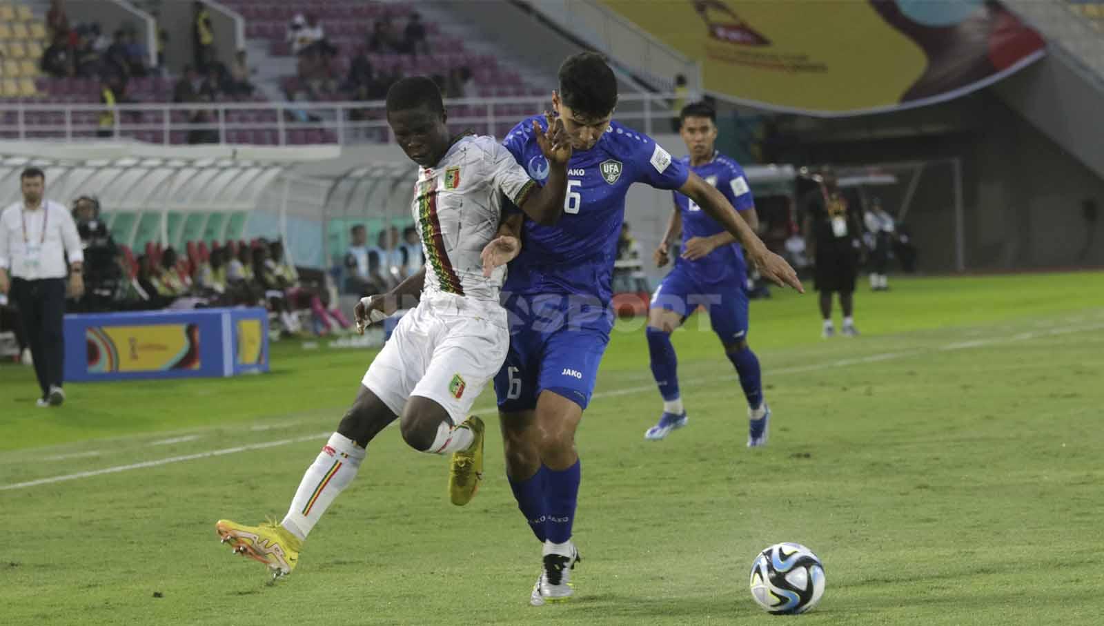 Bek Uzbekistan U-17, Ozodbek Uktamov, saat mengawal pergerakan winger Mali U-17 dalam pertandingan Piala Dunia U-17 2023 grup B di Stadion Manahan Solo, Jumat (10/11/23. Nofik Lukman Hakim/INDOSPORT