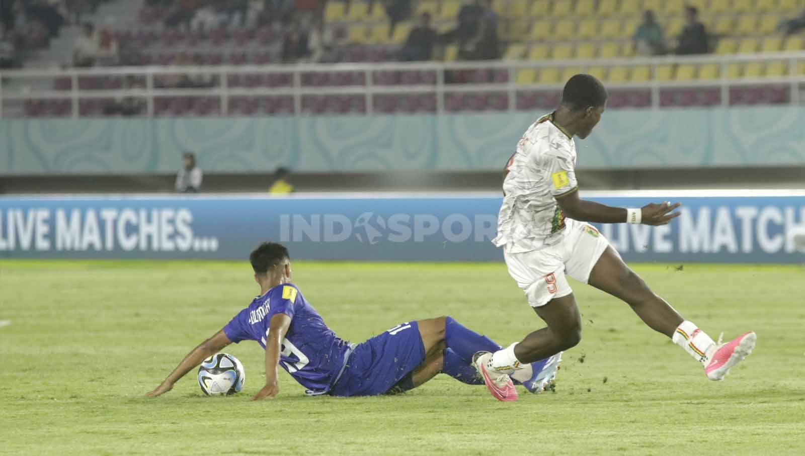 Bek Uzbekistan U-17, Sherzodbek Abdulboriev, sukses mematahkan serangan balik Mali U-17 lewat Salif Noah Leintu  dalam pertandingan Piala Dunia U-17 2023 grup B di Stadion Manahan Solo, Jumat (10/11/23. Nofik Lukman Hakim/INDOSPORT