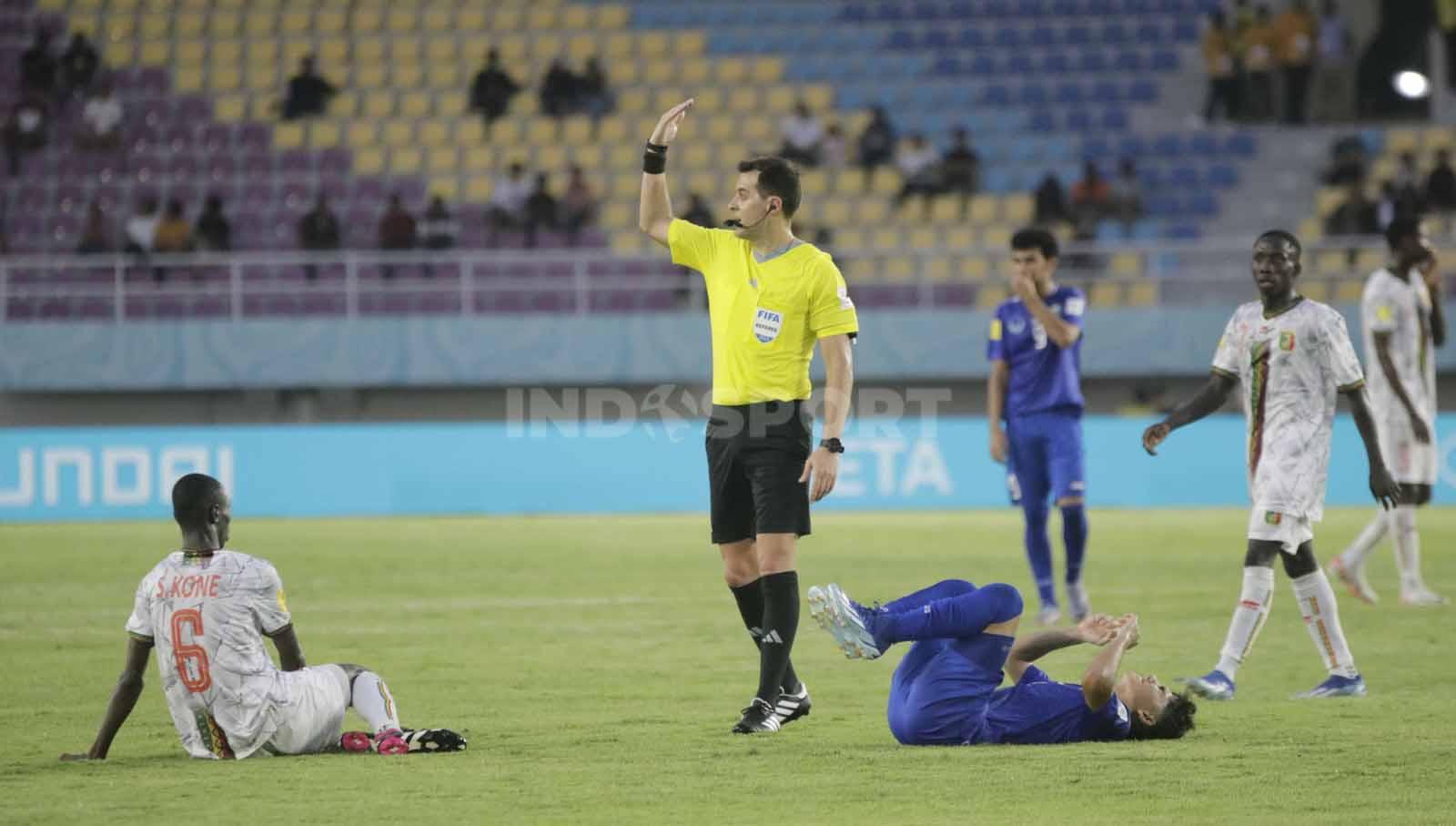 Wasit asal Uruguay, Gustavo Tejera, memanggil tim medis saat ada benturan pemain dalam pertandingan Piala Dunia U-17 2023 grup B antara Mali U-17 melawan Uzbekistan U-17 di Stadion Manahan Solo, Jumat (10/11/23. Nofik Lukman Hakim/INDOSPORT